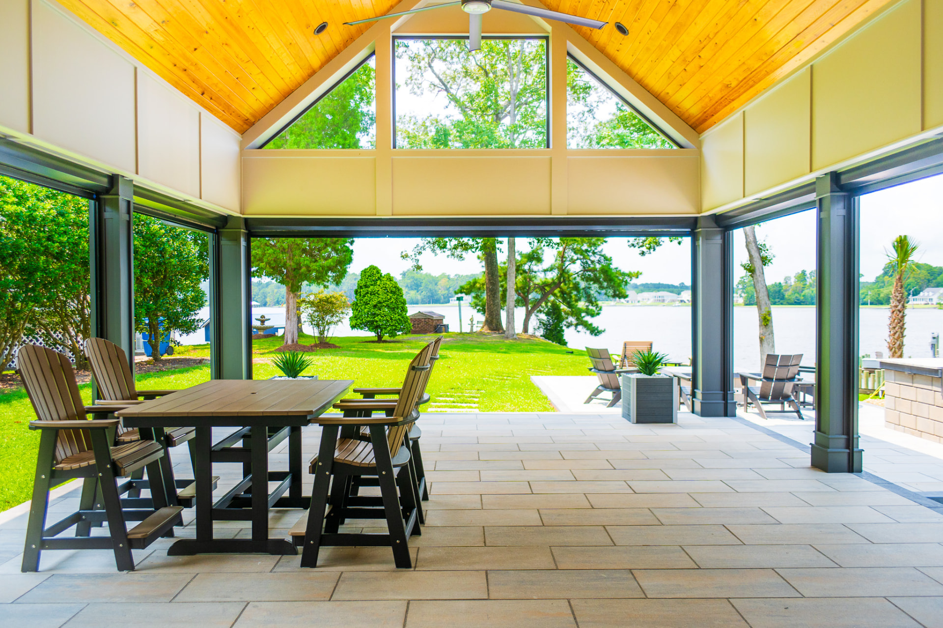 Covered pavilion with vaulted cedar ceiling and pub table framing a lake view