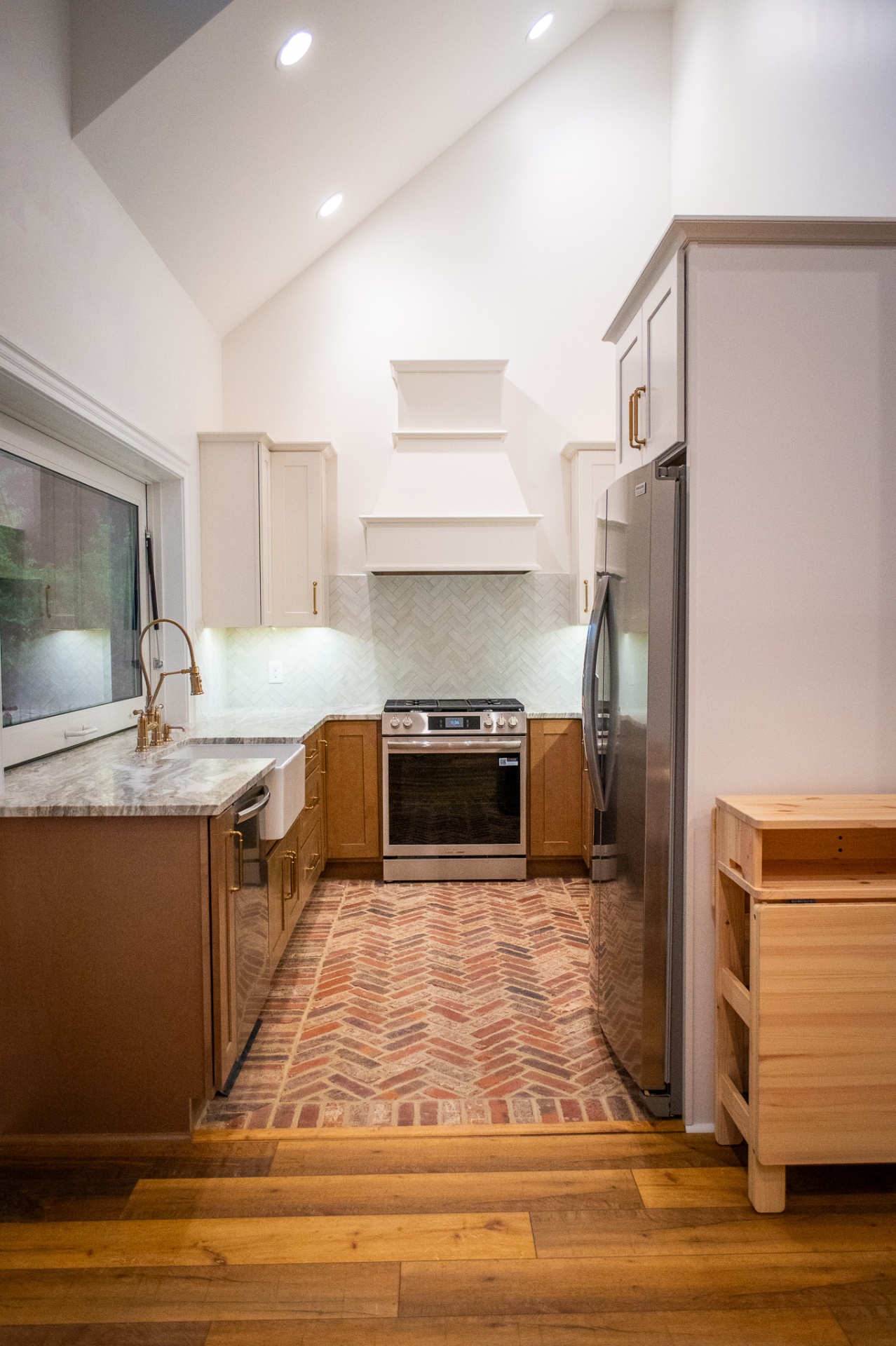 Pool house kitchen with vaulted ceiling and herringbone brick floor