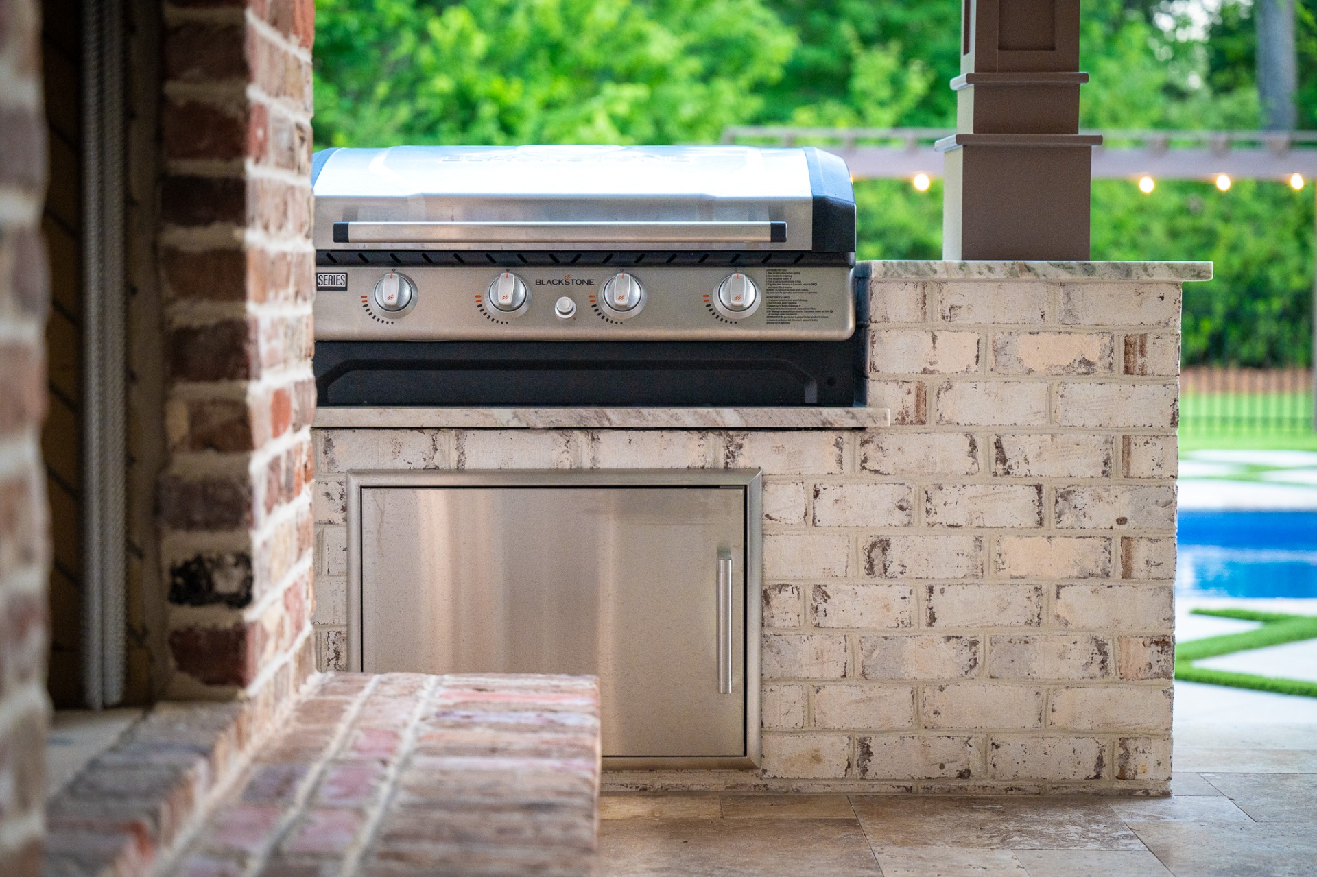 Built-in Blackstone griddle in whitewashed brick outdoor kitchen