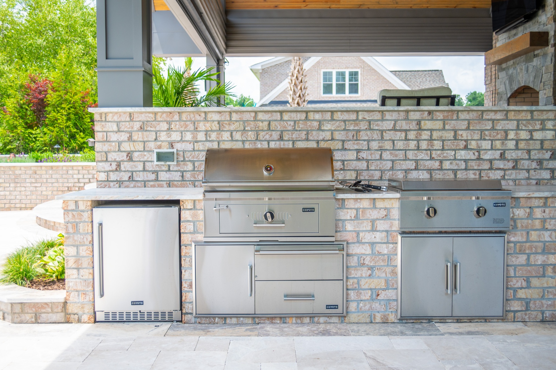 Built-in outdoor kitchen with Coyote grill and stainless cabinetry