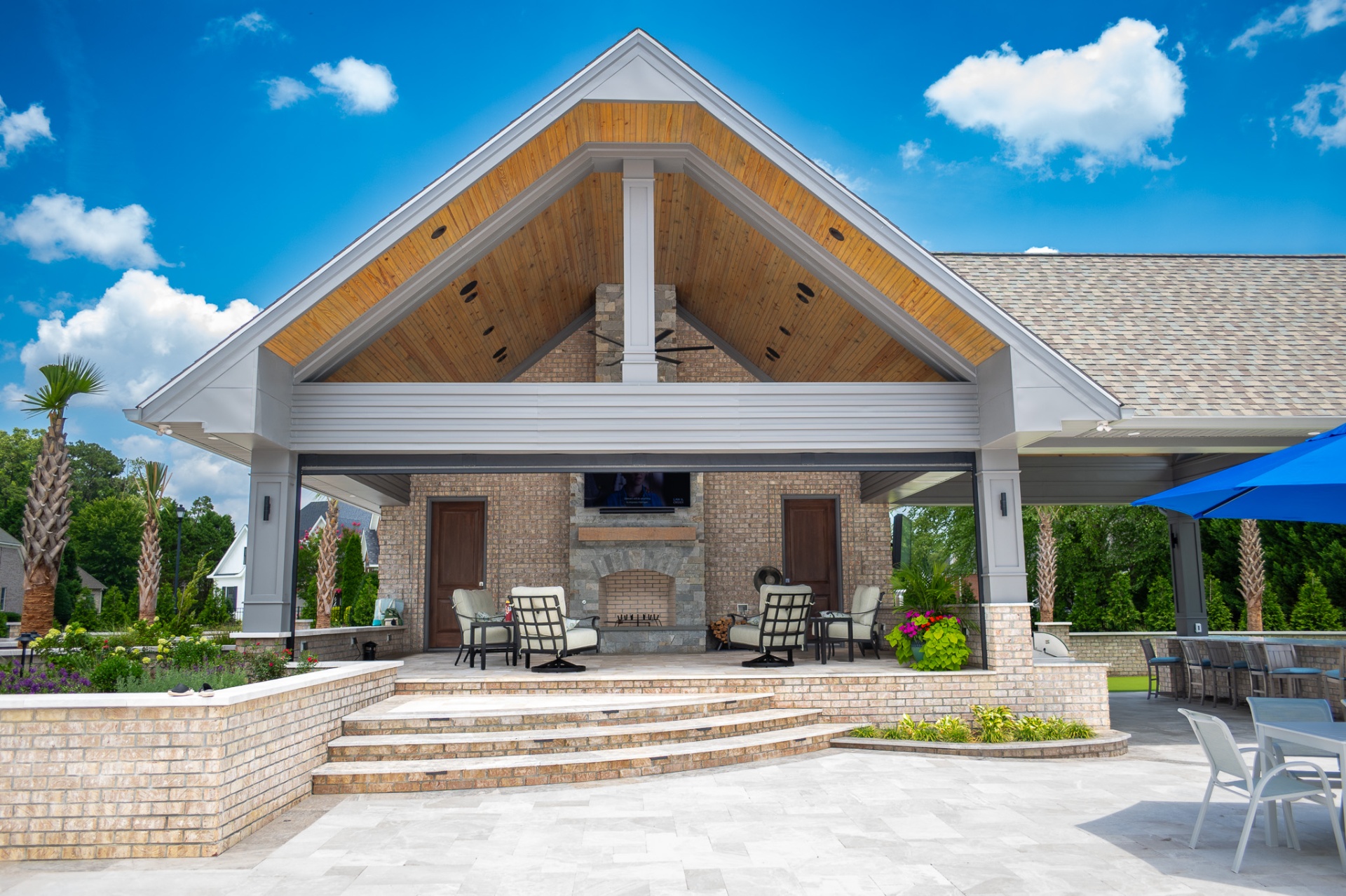 Cabana with stone fireplace and travertine patio